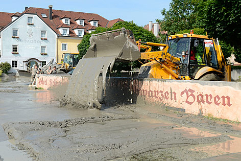 © APA/Helmut Fohringer Ein Bagger schaufelt Schlamm über eine Mauer