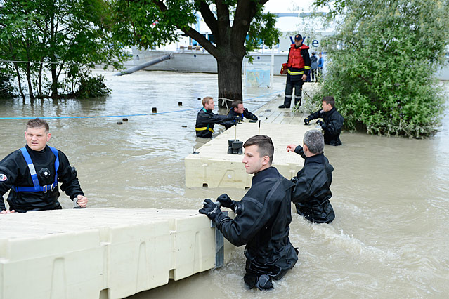 Feuerwehrleute beim Bau eines Versorgungssteges zu einem Schiff auf der Donau