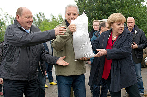 © AP/dpa/Arno Burgi Angela Merkel mit Sandsack
