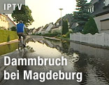 Mann fährt mit Fahrrad auf überschwemmter Straße