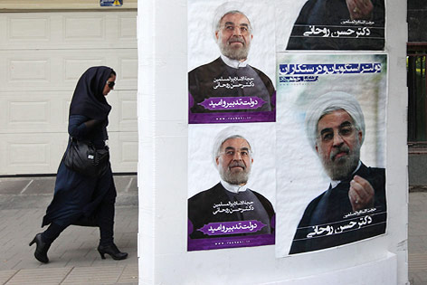 Frau geht an Wahlplakaten vorbei