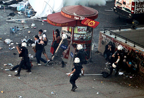 © AP/Thanassis Stavrakis Polizisten schlagen auf Demonstranten ein