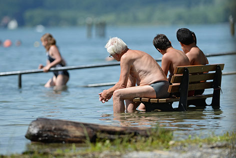 © APA/dpa/Felix Kästle Menschen sitzen auf einer Bank im Bodensee