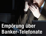 Banker hält sich beim Telefonieren die Hand vor den Mund