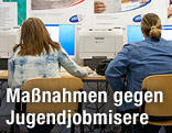 Junge Frauen sitzen vor einem Computern eines Arbeitsmarktservice