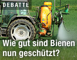 Traktor spritzt Acker mit Pestiziden