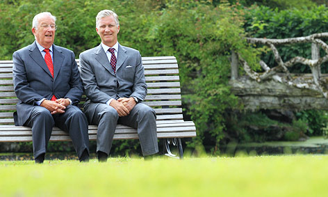 Belgiens König Albert II. sitzt gemeinsam mit seinem Sohn Kronprinz Philippe auf einer Parkbank