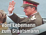 Belgiens König Albert II. sitzt in einem Auto und winkt