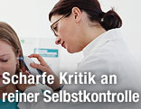 Ärztin misst Fieber im Ohr einer Patientin