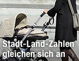 Frau schiebt Kinderwagen