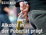 Mann h&auml;lt Corona-Flasche in der Hand