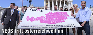 Die Spitzen der Partei NEOS mit einem Transparent der österreichweiten Unterstützungserklärungen vor dem Parlament