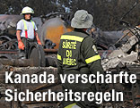 Feuerwehrleute neben Wrackteilen eines Zuges