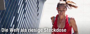 Junge Frau hört beim Joggen Musik
