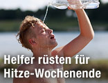 Mann gie&szlig;t sich Wasser &uuml;ber den Kopf