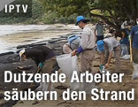 Arbeiter säubern den Strand