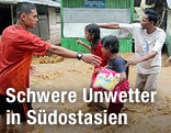 Menschen waten durch überflutete Straße