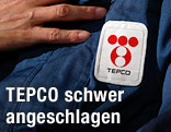 Arbeiter mit Tepco-Logo auf dem Overall