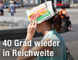 Mädchen hält sich Zeitung über den Kopf