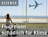 Frau beobachtet Passagierflugzeug beim Start
