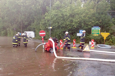 Feuerwehrmänner pumpen überflutete Straße ab