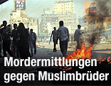 Mehrere Demonstranten auf der Straße vor einem Feuer