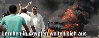 Mursi-Anhänger mit erhobenen Zeigefinger neben scharzen Rauchschwaden