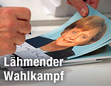 Kanzlerin Merkel unterschreibt eine Autogrammkarte