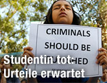 Mädchen mit einem Protestschild mit der Aufschrift "Criminals schould be punished"