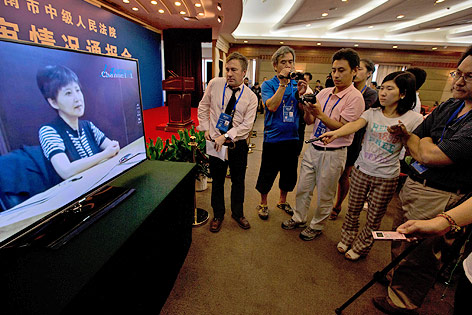 © AP/Ng Han Guan Journalisten blicken auf einen Fernseher, der die aufgezeichnete Aussage von Bo Xilais Frau zeigt