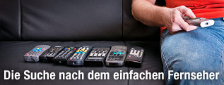 Mann mit mehreren Fernbedienungen