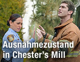 In einer Szene aus "Under the Dome" stehen Natalie Martinez und Josh Carter an einer unsichtbaren Wand
