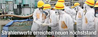 Arbeiter in Strahlenschutzanzügen in Fukushima
