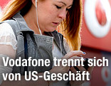 Frau telefoniert vor Vodafone Logo