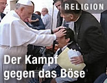 Papst Franziskus legt Hände auf den Kopf eines jungen Mannes