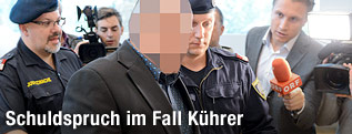 Verurteilter wird von Polizei abgeführt