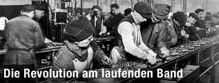 Arbeiter an einem Fließband im Jahr 1913