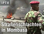 Kenianischer Soldat vor brennenden Reifen