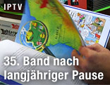 Mann bl&auml;ttert durch die neue Ausgabe „Asterix bei den Pikten“