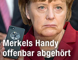 Deutsche Kanzlerin Merkel hält mit traurigem Blick ein Handy in die Kamera