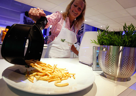 Frau präsentiert eine Fritteuse von Philips auf der IFA im Jahr 2010
