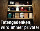 Bestattungsurnen in einem Holzschrank