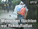 Mann trägt Kind durch Sturm