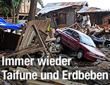 Autowrack neben zerstörtem Haus