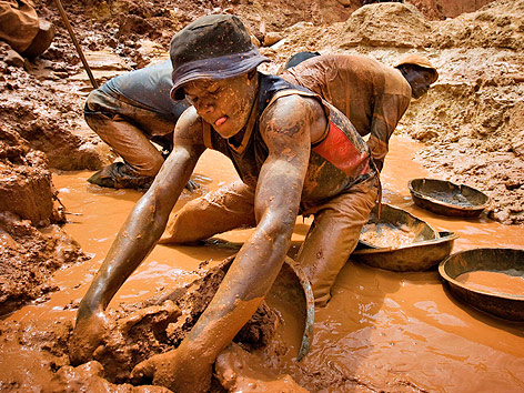 Kongolesischer Arbeiter sucht im Schlamm nach Gold
