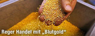 Eine Hand h&auml;lt Goldgranulat