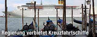 Venezianische Gondeln vor eine gro&szlig;en Kreuzfahrtschiff
