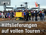 Taifun-Opfer und Hubschrauber mit Hilfslieferungen