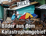 Eine Frau trocknet Wäsche inmitten der Verwüstung