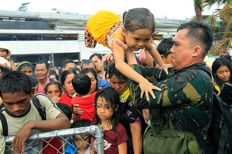 © APA/AP/Wally Santana Soldat hilft Kind über Absperrung